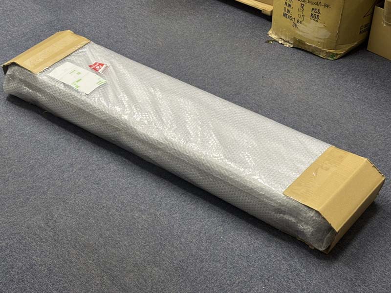 両端が段ボールで補強された荷物に発送伝票が貼れれている